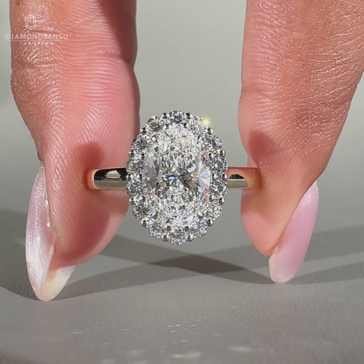 Oval diamond engagement ring featuring a cathedral setting in yellow gold
