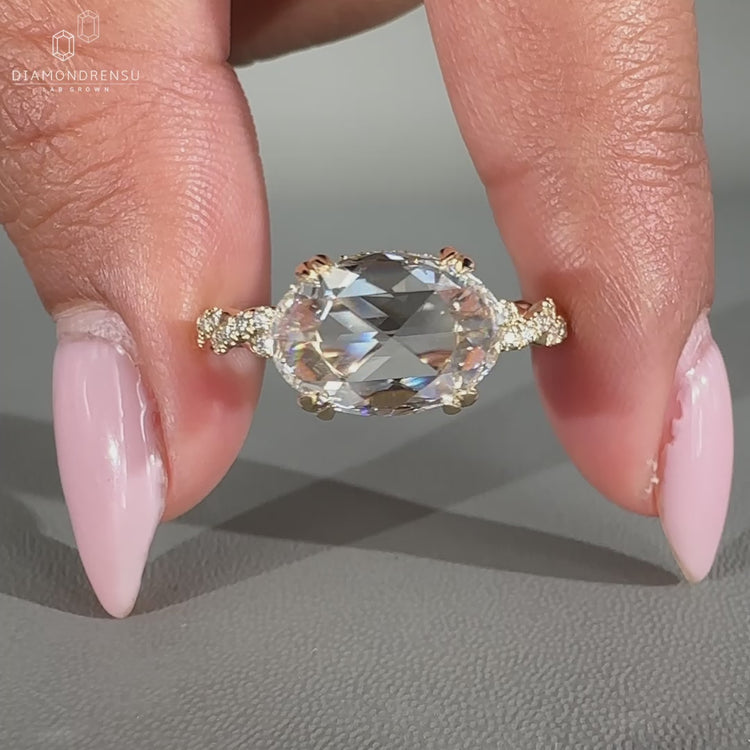 Elegant east west oval ring with a hidden halo, crafted for a unique engagement style.
