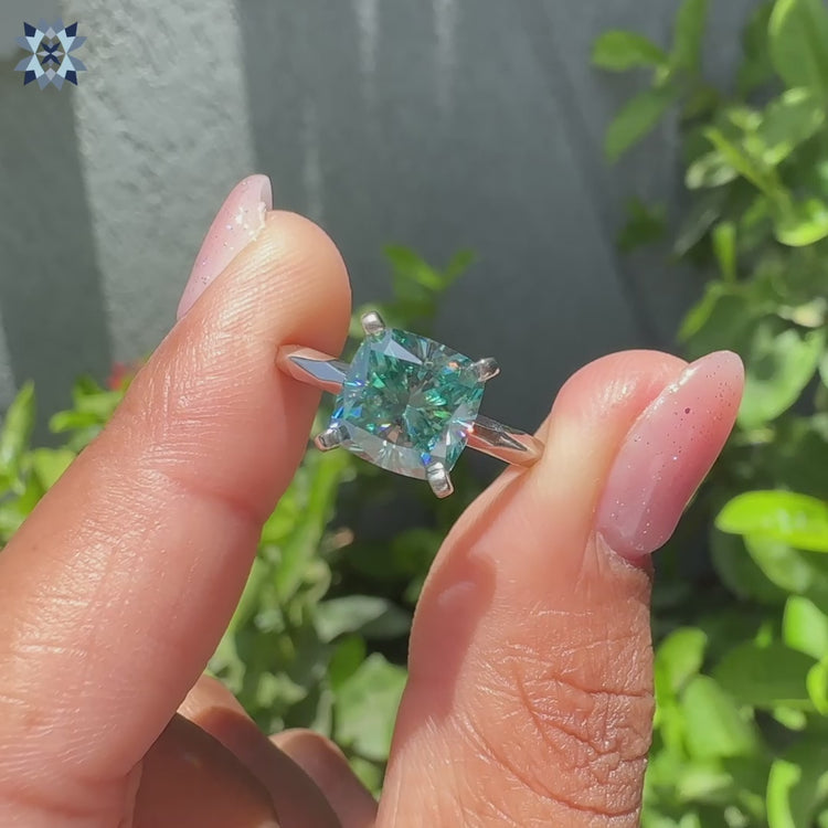 Cushion cut solitaire ring with a sparkling moissanite stone, crafted in a refined, timeless style.
