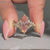 Pink marquise diamond ring with round side stones.