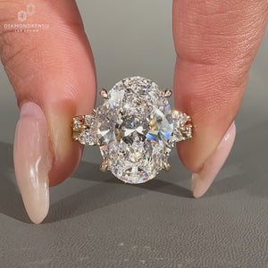 Oval lab grown diamond ring with marquise and round side stones.
