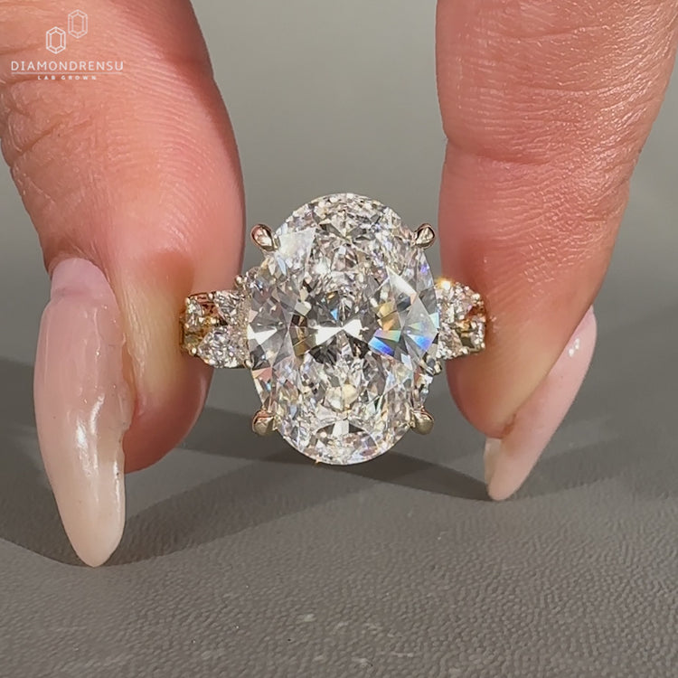 Oval lab grown diamond ring with marquise and round side stones.
