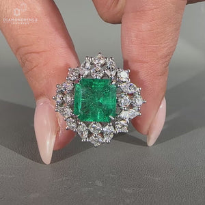 Asscher cut emerald gemstone ring in white gold.
