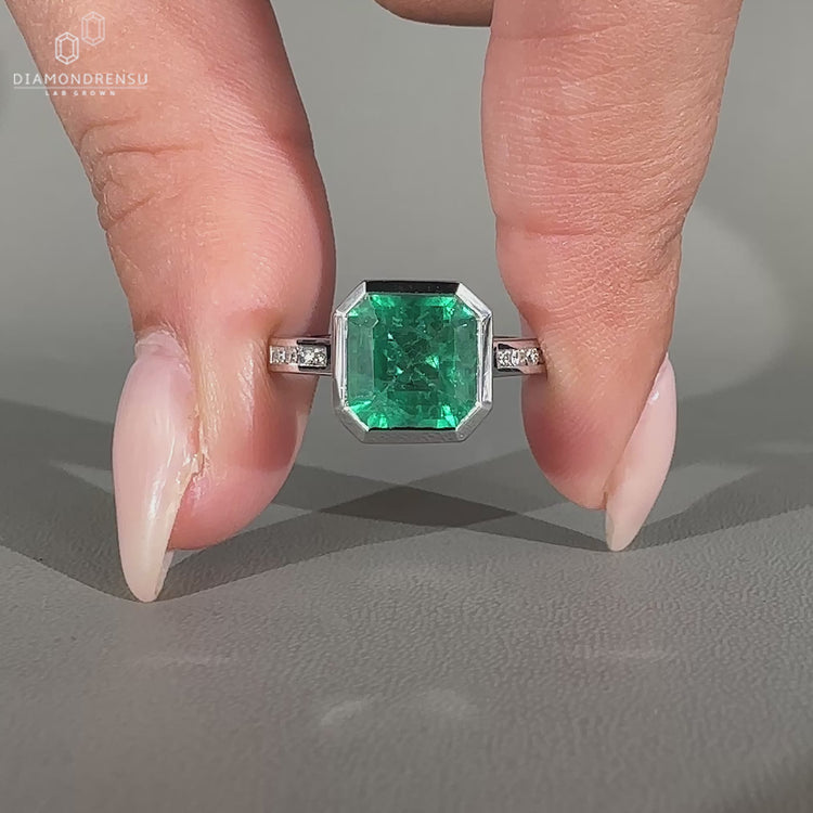 Bezel setting emerald engagement ring.
