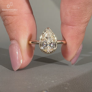 Lab Grown Diamond pear cut engagement ring with bezel setting.
