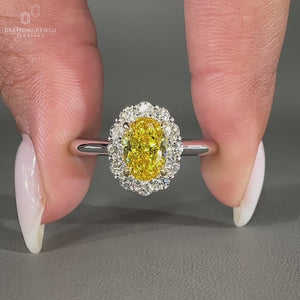 Canary yellow oval diamond ring with round cut side diamonds.
