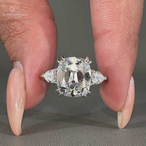 Vintage style diamond ring with cushion old mine center and pear sides.