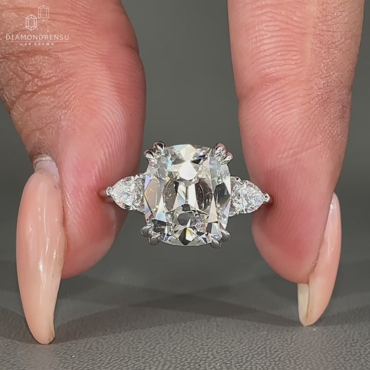 Vintage style diamond ring with cushion old mine center and pear sides.
