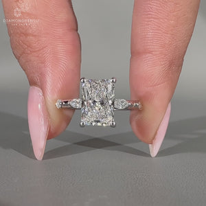 Hidden halo ring featuring radiant cut diamond and round cut accents.
