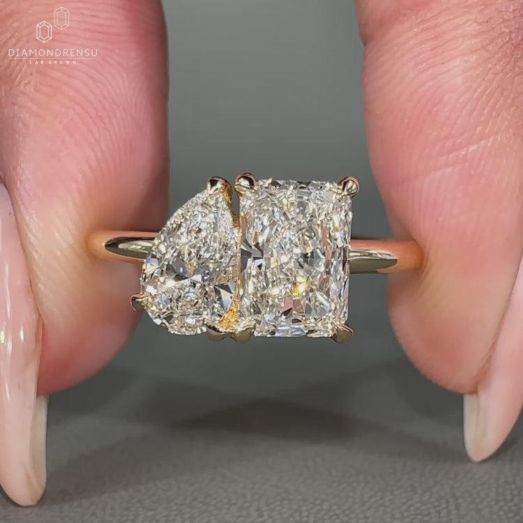 Radiant cut diamond ring with pear cut stones set in a yellow gold band.
