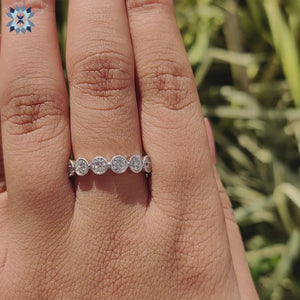 Round cut moissanite placed in a modern wedding band.
