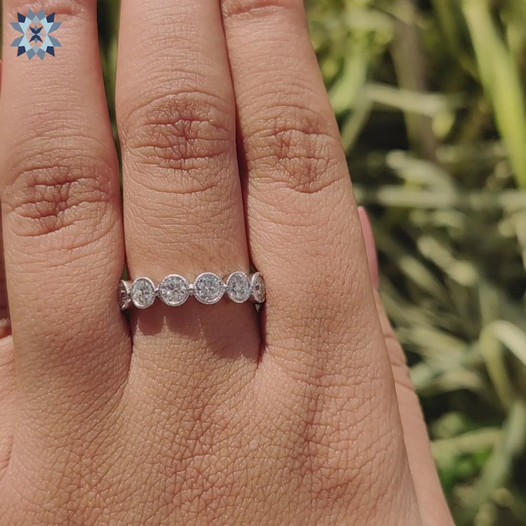 Round cut moissanite placed in a modern wedding band.
