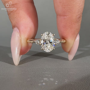 Oval centre diamond ring with round sides and filigree shank.