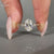 Oval centre diamond ring with round sides and filigree shank.