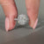 Elongated cushion diamond ring with white gold band and halo diamond design.