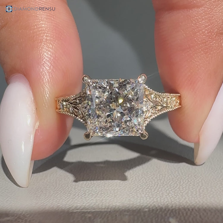 Princess cut Art Deco engagement ring with round side stones.