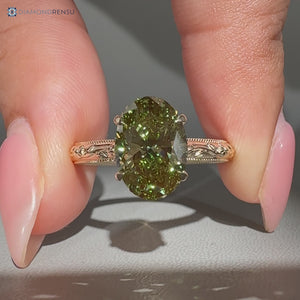 Green oval center stone in a cathedral setting.