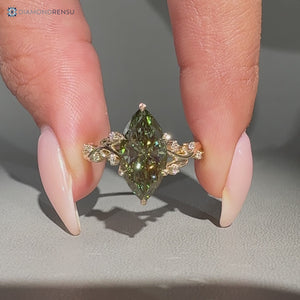Green marquise cut ring with round side stones.
