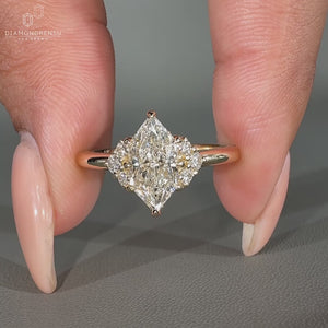 Muse ring featuring a marquise center diamond and round side stones.
