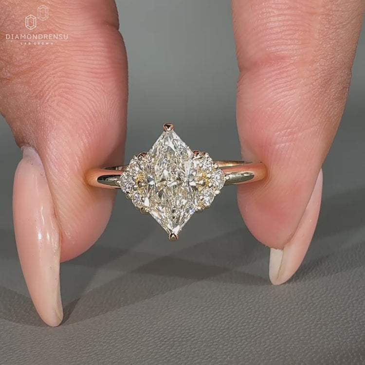 Muse ring featuring a marquise center diamond and round side stones.
