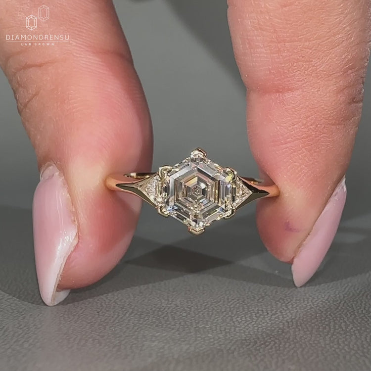 Hexagon step cut diamond three stone engagement ring.
