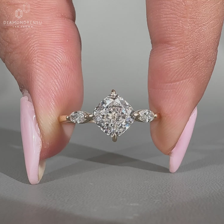 Cushion engagement ring with marquise side stone.
