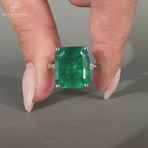 Distance pave engagement ring with emerald center.
