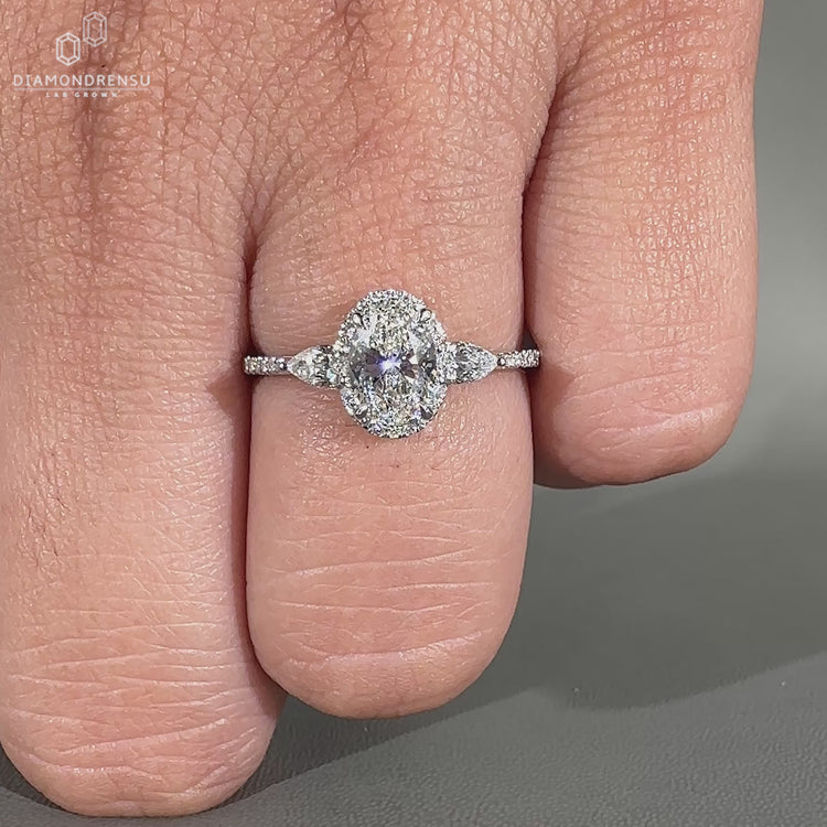 Oval engagement ring with halo and pave round diamonds.