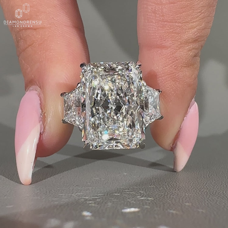 Radiant cut ring in a cathedral setting ring with side stones.
