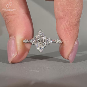 Side stone ring crafted in white gold with milgrain detail.
