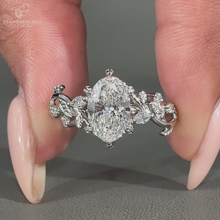 Oval cut diamond set in a flowing vine design.
