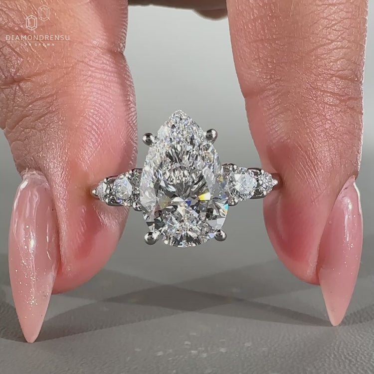 Pear engagement ring with round side stones.
