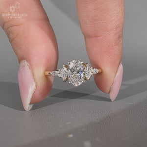 Oval diamond ring with marquise and round side stones.