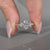 Oval diamond ring with marquise and round side stones.