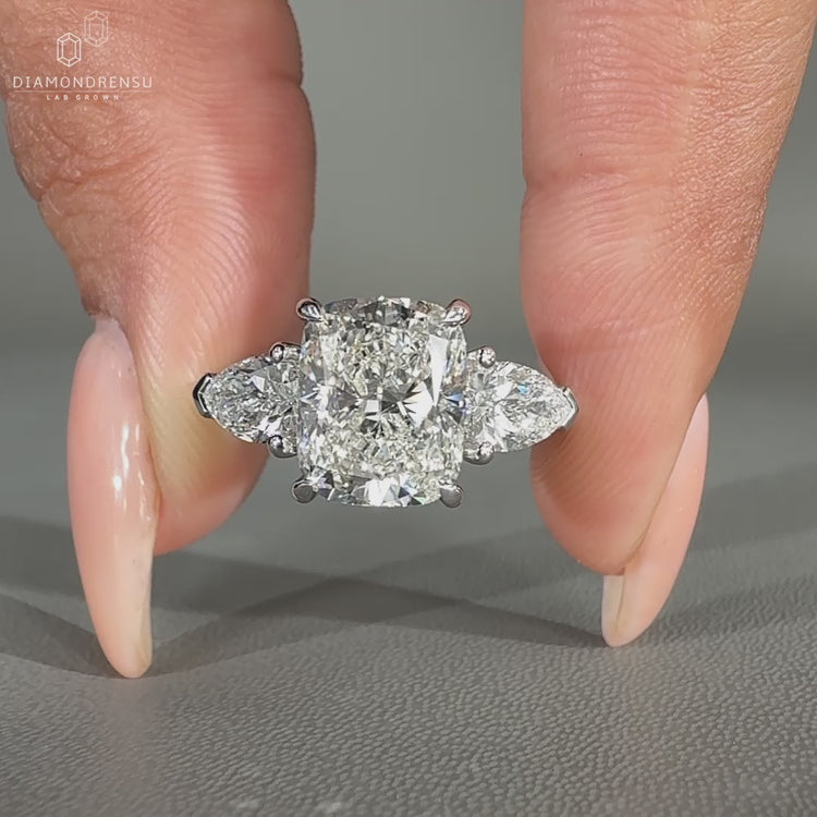 Engagement ring featuring 2 pear cut side stones and cushion cut center.
