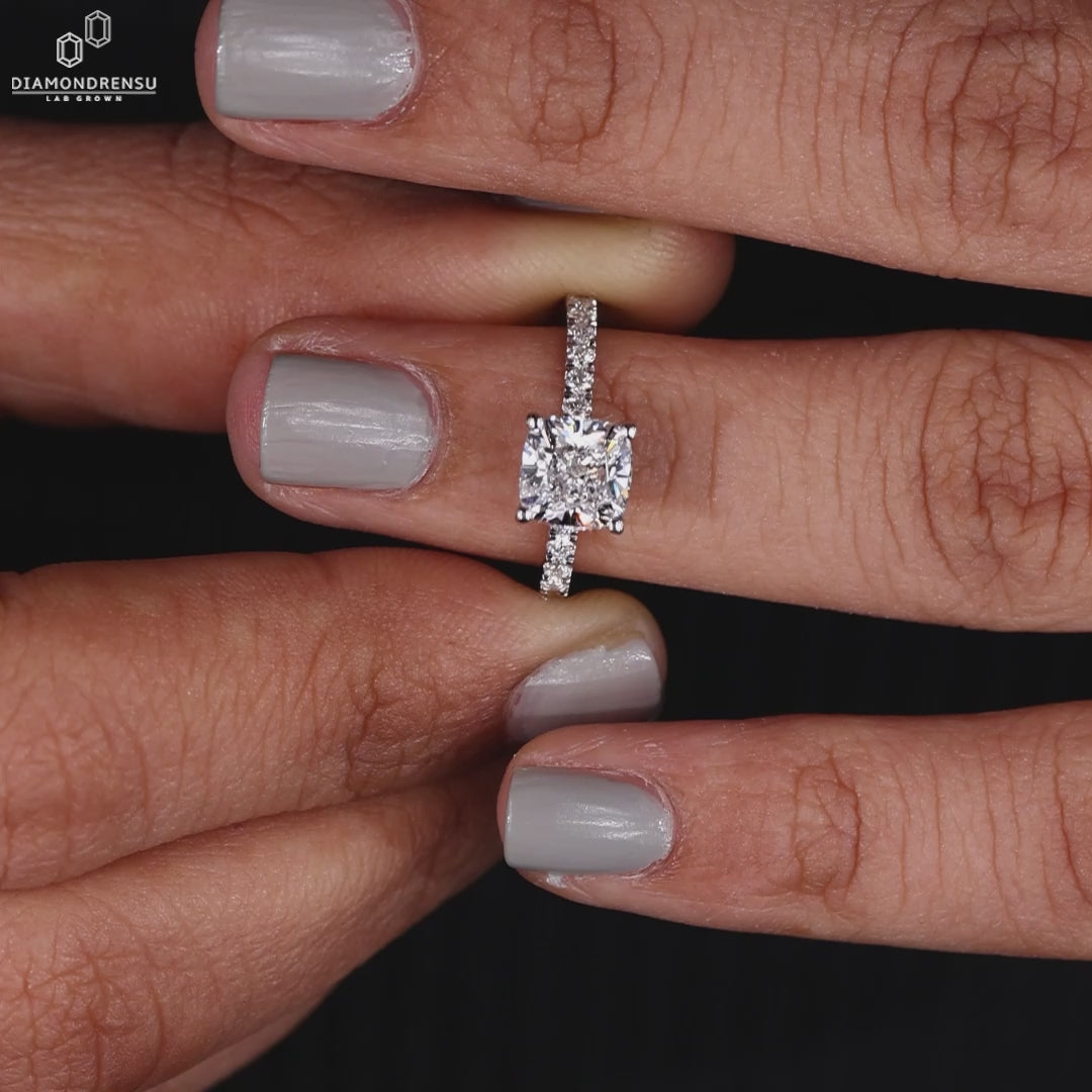 Close-up of a lab-grown cushion cut diamond engagement ring in a jewelry box.