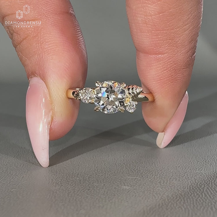 Three stone nature inspired ring with round old European cut center.
