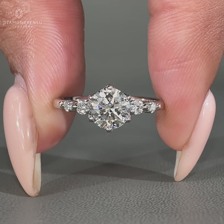 Tapered shank band with round cut side stones and 5 diamond ring design in a white gold engagement ring.
