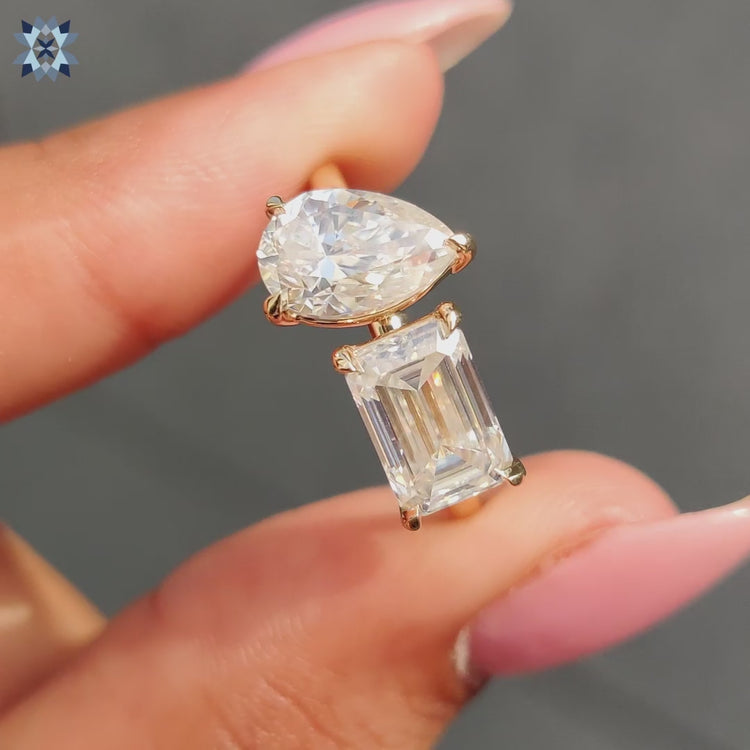 Stunning Pear cut moissanite and emerald cut moissanite set in a classic yellow gold engagement ring.
