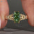 Coffin cut diamond ring with a green center stone.