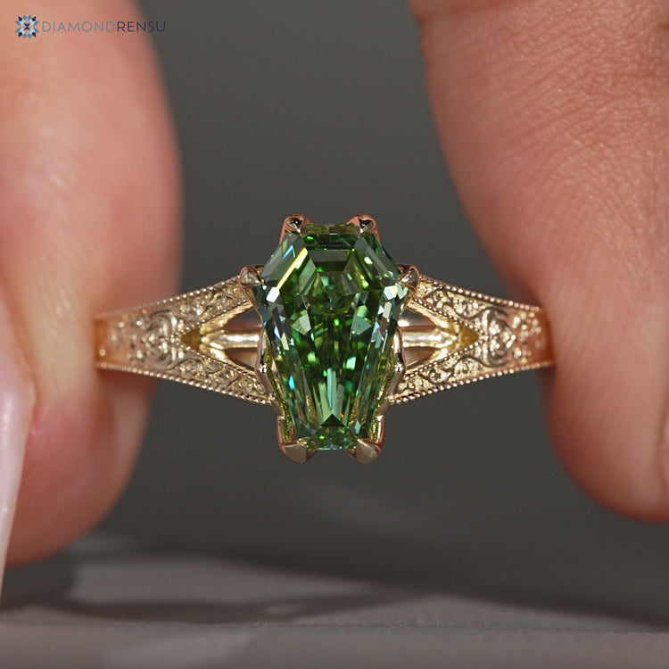 Coffin cut diamond ring with a green center stone.