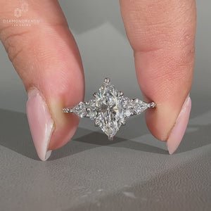 Side stone ring with marquise center diamond.
