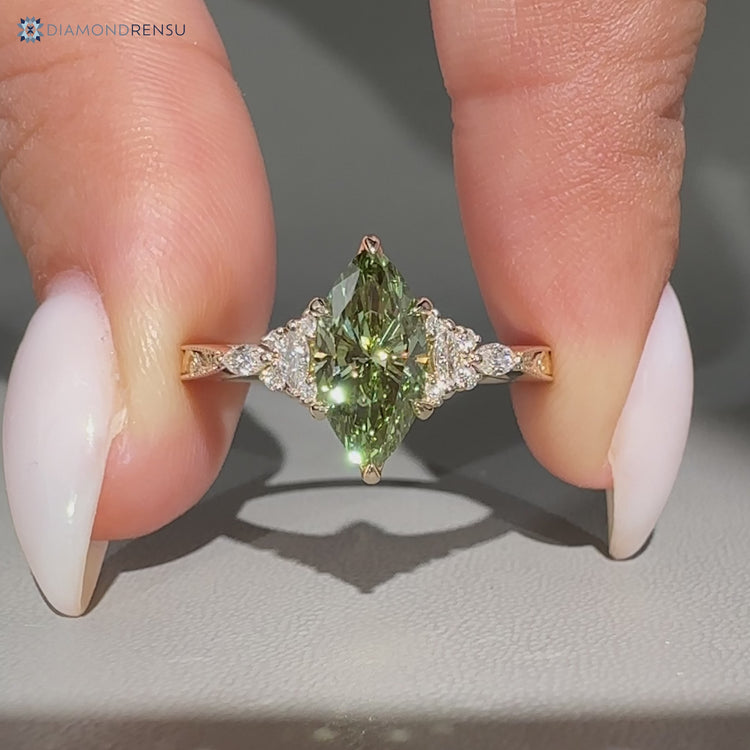 Green marquise Art Deco diamond ring with round side stones.