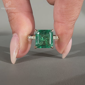 Green emerald gemstone ring in yellow gold.
