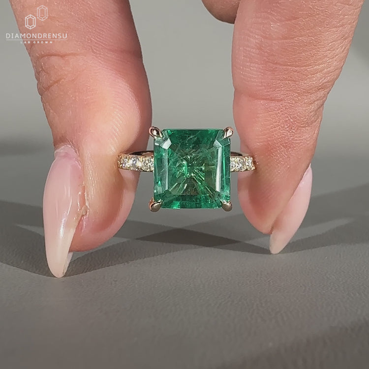 Green emerald gemstone ring in yellow gold.
