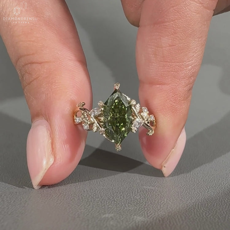 Green diamond ring in handmade yellow gold design.
