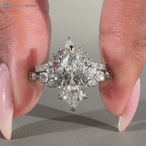 Round side stones complement this marquise wedding ring.