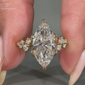 Round cut side stones set in a marquise cut engagement ring with 6 claw prong setting and yellow gold engagement ring.
