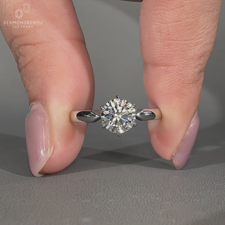 Round cut diamond ring featuring solitaire setting in white gold.
