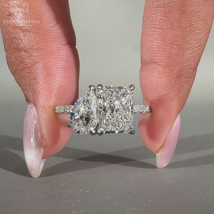 Pear and radiant diamond ring set in white gold, perfect for a modern and striking look.
